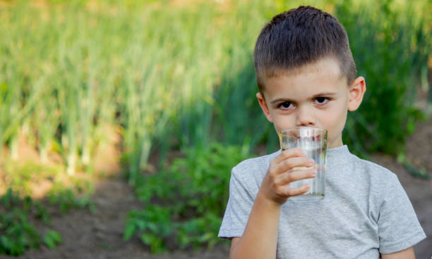 istock The child drinks water from a glass. Selective focus. 1497654600