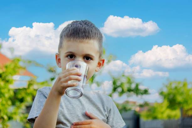 istock The child drinks water from a glass. Selective focus. 1497654603
