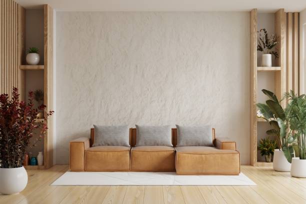 istock Living room wall mockup with leather sofa and decor on white plaster wall background. 1497655455