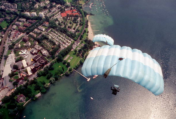 Skydive athletes perform above Swiss mountain landscape