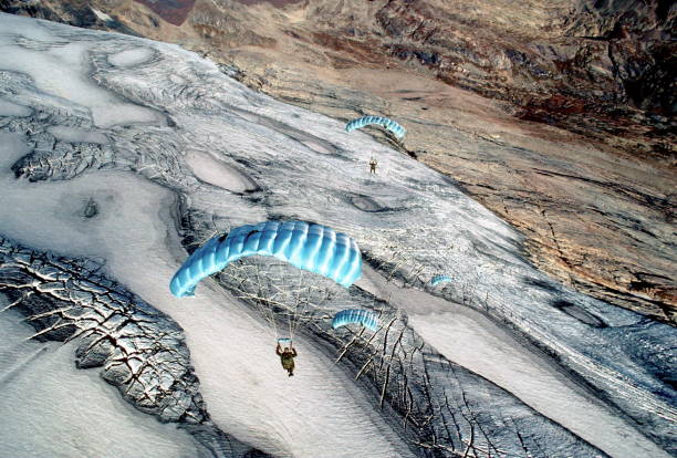 Skydive athletes perform above Swiss mountain landscape