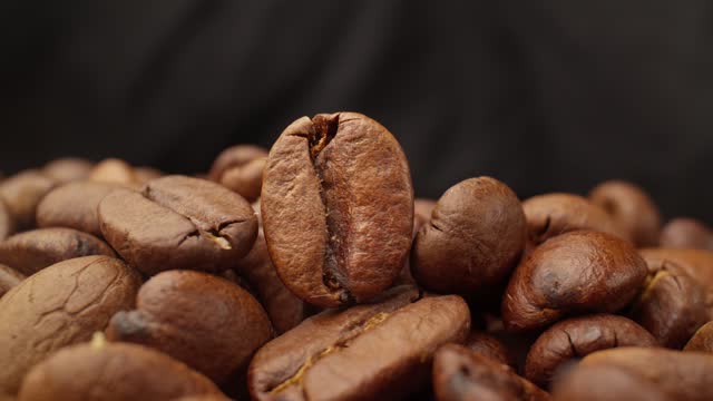 Pile of roasted brown coffee beans. Arabica coffee beans. Food industry.