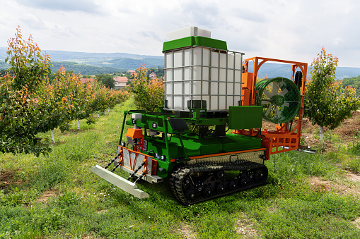 Autonomous robot sprayer works in a fruit garden. Smart farming concept