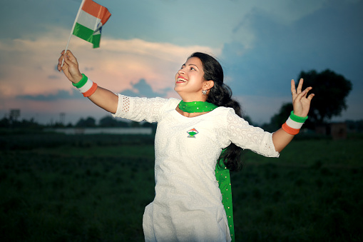 Happy girl of Indian ethnicity jumping in air with holding Indian flag on Independence day, India. Independence Day is celebrated annually on 15 August as a public holiday in India commemorating the nation's independence from the United Kingdom on 15 August 1947, the day when the provisions of the Indian Independence Act, which transferred legislative sovereignty to the Indian Constituent Assembly, came into effect.