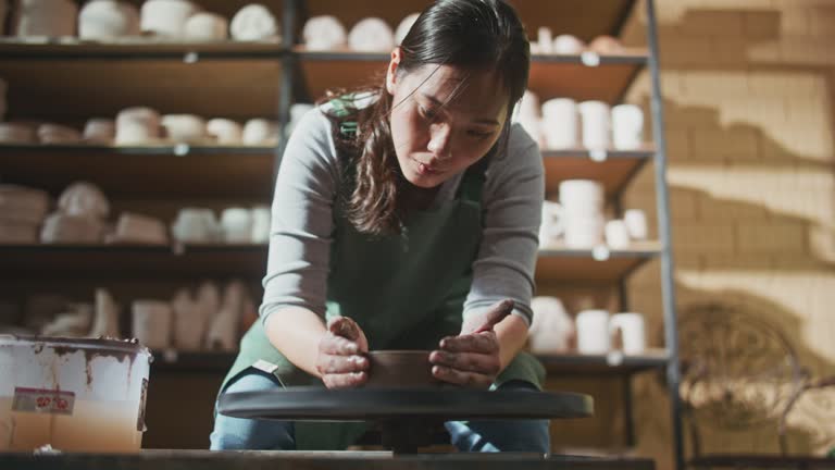 Young artist in the pottery studio making bowl with her hands, handmade creative artist, Small Business