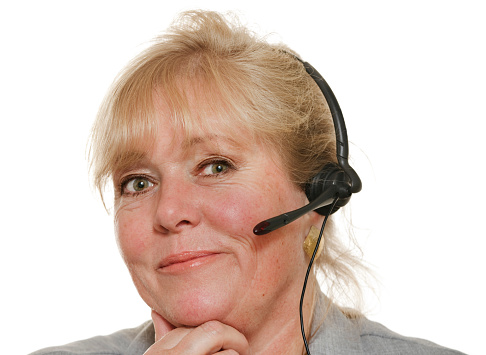Mature customer service representative with headset, chin in hand