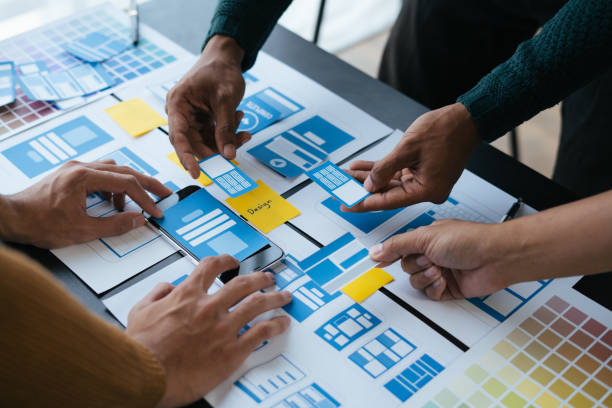 istock Close up view of ux developer and ui designer brainstorming about mobile app interface wireframe design. 1497669227