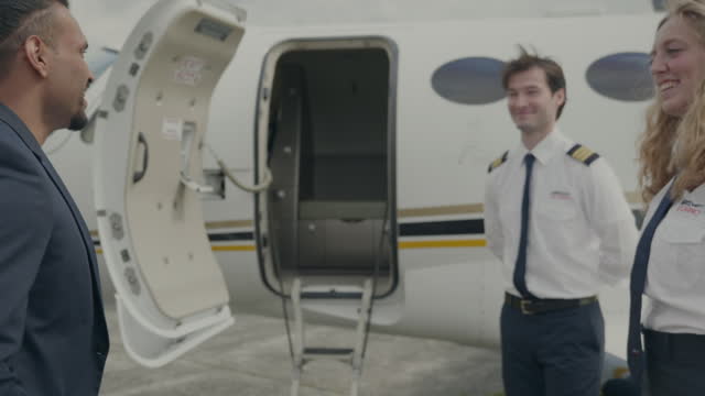 Young corporate businessman on tarmac arrives at private jet plane