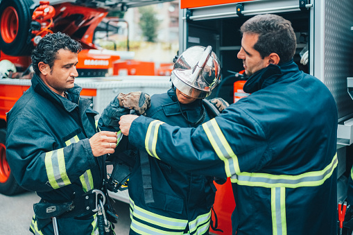 Firefighter man giving instructions to a rookie colleague