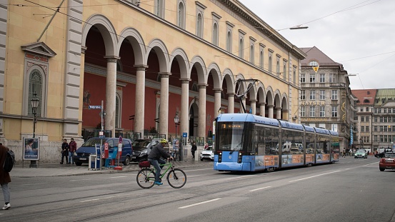 Munich, Germany – September 28, 2021: A bus and cars driving down the street with buildings by the side