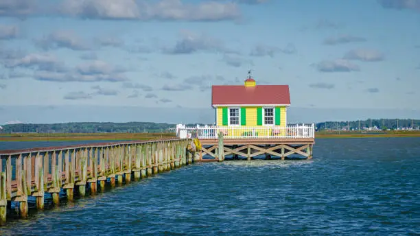 Blick auf einen Bootssteg mit einem kleinen, bunten Holzhaus im Hafen von Chincoteague in Virginia