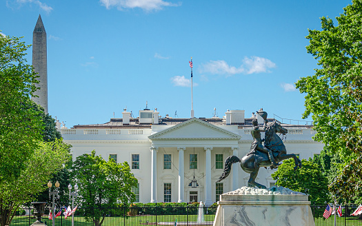 Daytime panoramic view of the northern facade of the white house featuring its classical portico with columns (Washington DC).