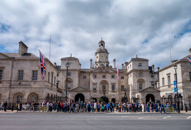 London,England - May 10th 2010Female tourist taking a photograph of her teenage sons wearing union jack hats next to the mounted sentry guard in the sentry box facing whitehall at Horseguards. The household cavalry are a top London tourist attraction and maintain composure and vigil at the entrance despite all the attention.