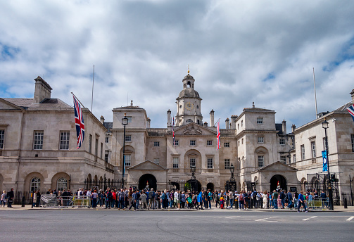 Large crowd of people standing outside the gates of Horse Guards in Whitehall, Central London, on the day after the Coronation of King Charles III.