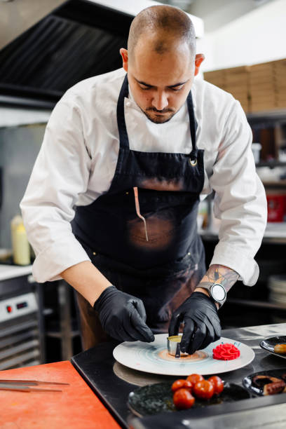 istock Confident male chef garnishing a plate in commercial kitchen 1497679578
