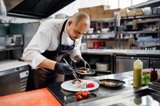 istock Confident male chef garnishing a plate in commercial kitchen 1497679595