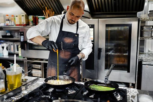 Professional male chef preparing food in the commercial kitchen