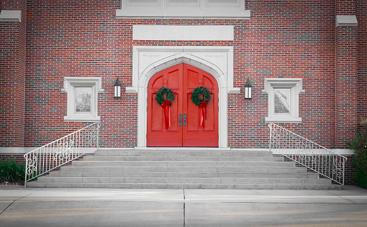 The entrance to a historic church with red double doors