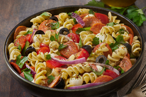 The Viral Pepperoni Pizza Pasta Salad with, Bocconcini Cheese, Cherry Tomatoes, Black Olives, Red Onion, Italian Parsley and Red Peppers