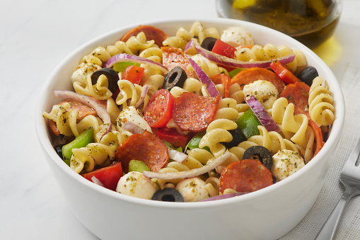 The Viral Pepperoni Pizza Pasta Salad with, Bocconcini Cheese, Cherry Tomatoes, Black Olives, Red Onion, Italian Parsley and Red Peppers
