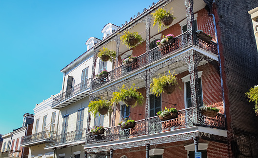 A view of a the tall galleries with hanging plants on the historic buildings in the French Quarter of New Orleans, Louisiana