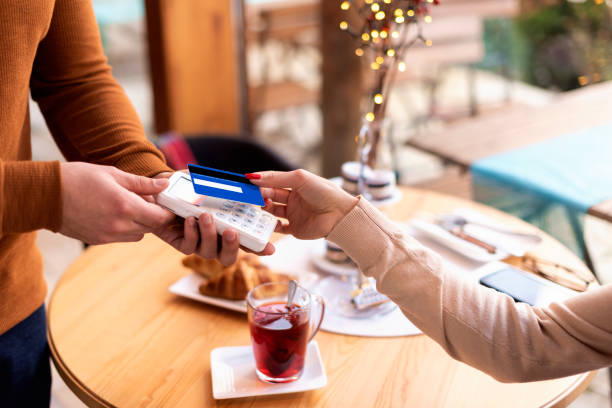 istock Close-up of a woman's hand while paying with card in a cafe 1497683311