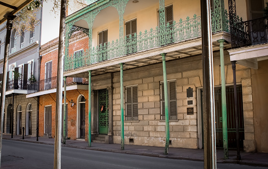 A tall gallery with green poles in the French Quarter of New Orleans, Louisiana