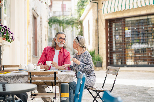 Mature couple as tourist, enjoying local coffee at side street cafe , Cyprus