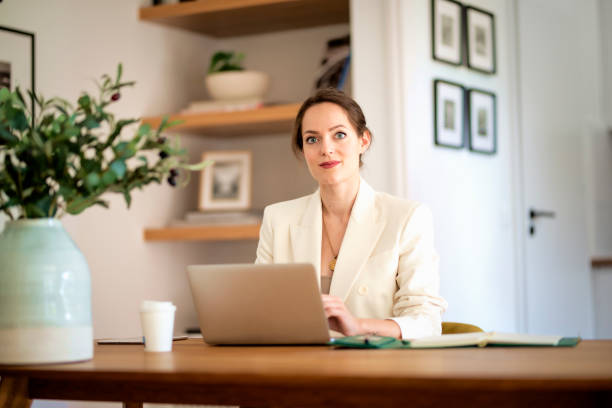 istock Young businesswoman using laptop and working from home 1497684579