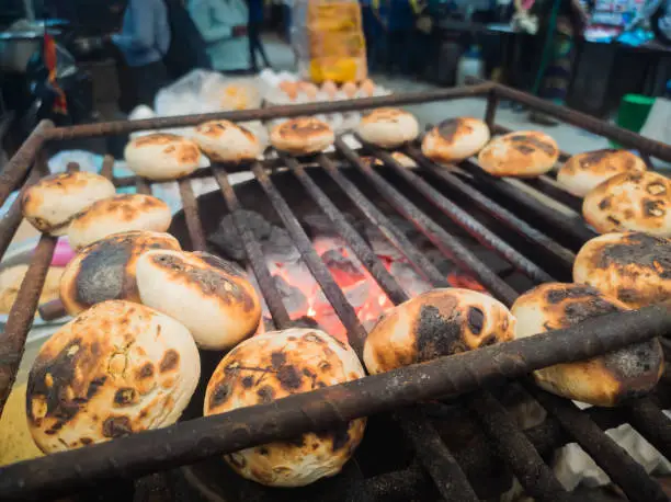 Litti or litthi balls are being grilled on open flame. These traditional bihari food are dumplings made of wheat flour and stuffing of gram flour which are smoked or roasted to be served with chokha.