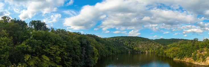 Panorama of a natural body of water in a forest landscape. Brno Reservoir.