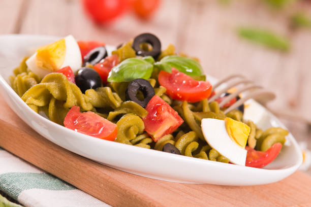 Fusilli pasta with cherry tomatoes, eggs and black olives.