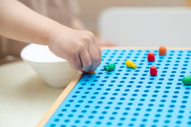 istock Close up toddler playing with montessori peg board 1497696731