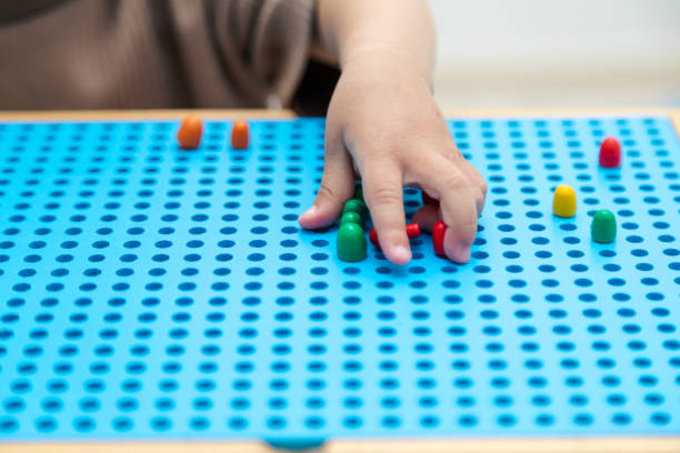 istock Close up toddler playing with montessori peg board 1497696750