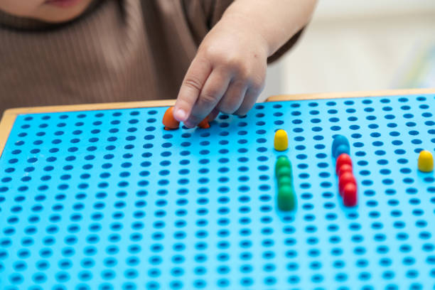 istock Close up toddler playing with montessori peg board 1497696791