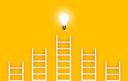 Ladder reaches up to a lit light bulb representing an Idea, creativity, invention concept.