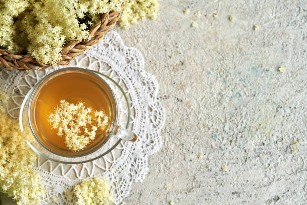 istock Herbal tea with fresh elderberry flowers on textured background with copy space 1497698447