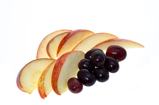 Slices of apple with grapes - white background