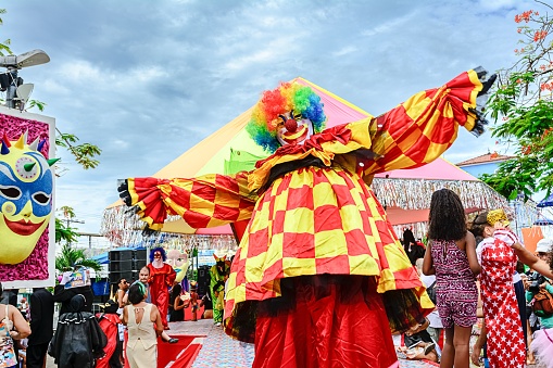 Salvador, Brazil – February 28, 2017: A clown wearing brightly-colored red and yellow costume during a carnival in Salvador