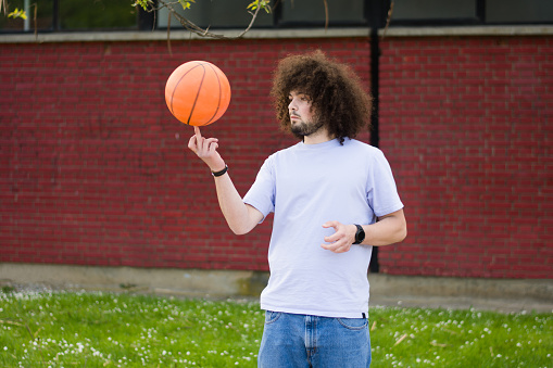 Portrait of a young man having fun on the street after playing basketball