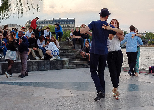 Tango in Paris : Tango on riverbank of Seine in fantastic May. 3 pairs dancing at sunset . (this dance not so easy) Man in hat in centre with smiling woman