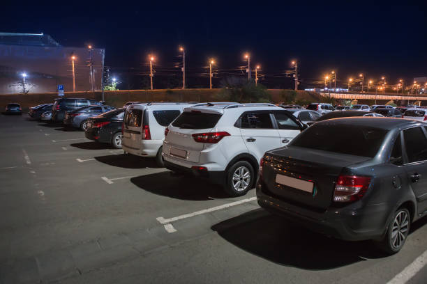 istock Cars in an illuminated parking lot 1497709894
