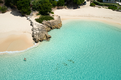 Aerial of woman coming out of water at Meads Bay Beach, Anguilla