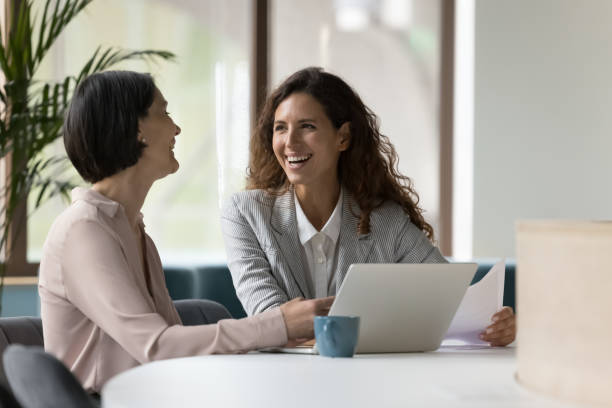 istock Two businesswomen working in office, laughing, joking during workflow 1497712526