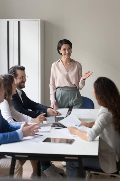 Mature businesswoman lead group meeting in conference room stock photo