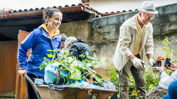 istock Woman volunteer moving trash and garbage bags using wheelbarrow 1497713425