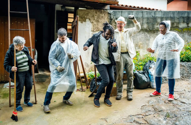 group of volunteers cheering during a community cleanup day - active seniors enjoyment driveway vitality imagens e fotografias de stock