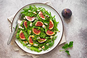 Fresh salad with figs, arugula and dor blue cheese. Top view, flat lay.