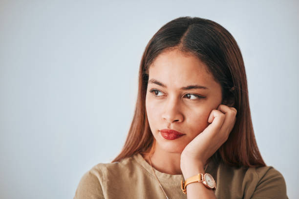 istock Serious woman, thinking and space for idea in studio with advertising or product placement. Face of female on white background with doubt, planning or contemplating problem, plan or decision 1497717595