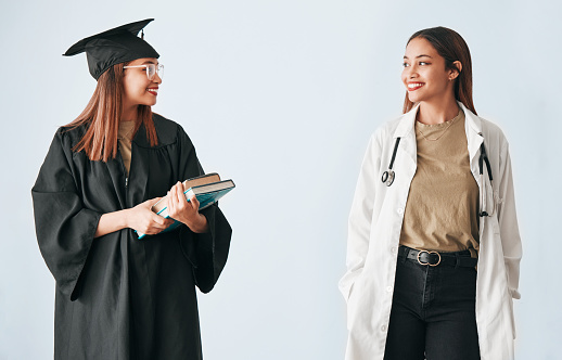 Graduation, medicine and medical student with degree, certificate and diploma achievement isolated in a studio white background. Scholarship, future and happy woman graduate or certified doctor